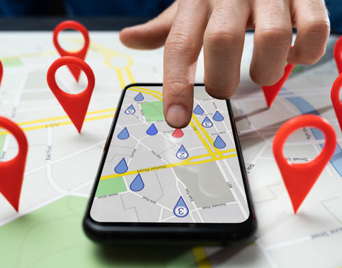 Person holds smartphone with GPS map on the screen. You can find Merak locations in Antwerp, Brussels, Mechelen, and Hoogstraten.