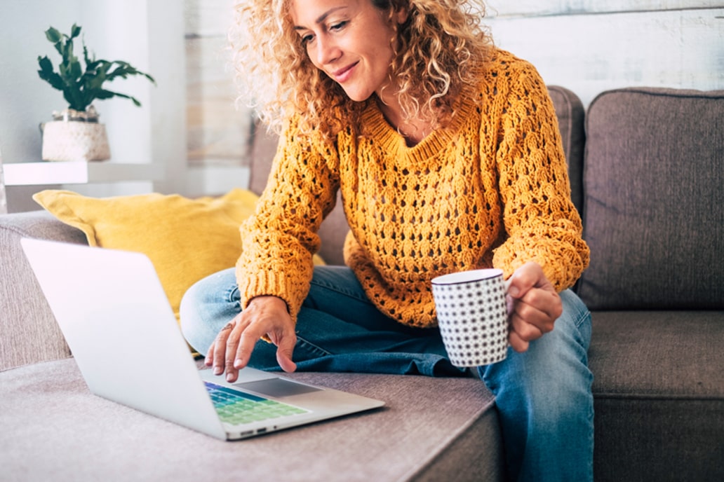 Woman sitting at her coffee table behind her laptop