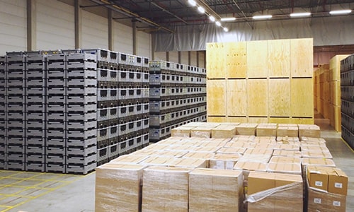 Storage area filled with stacked crates and wooden boxes.